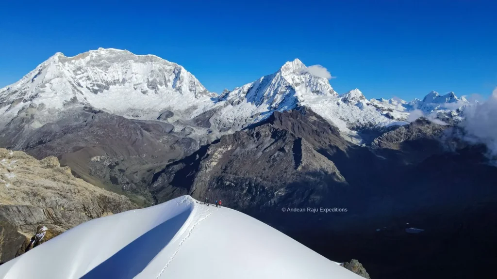 Snowy summit ridge of Nevado Mateo with two climbers, facing Huascarán and Chopicalqui above the Ulta valley