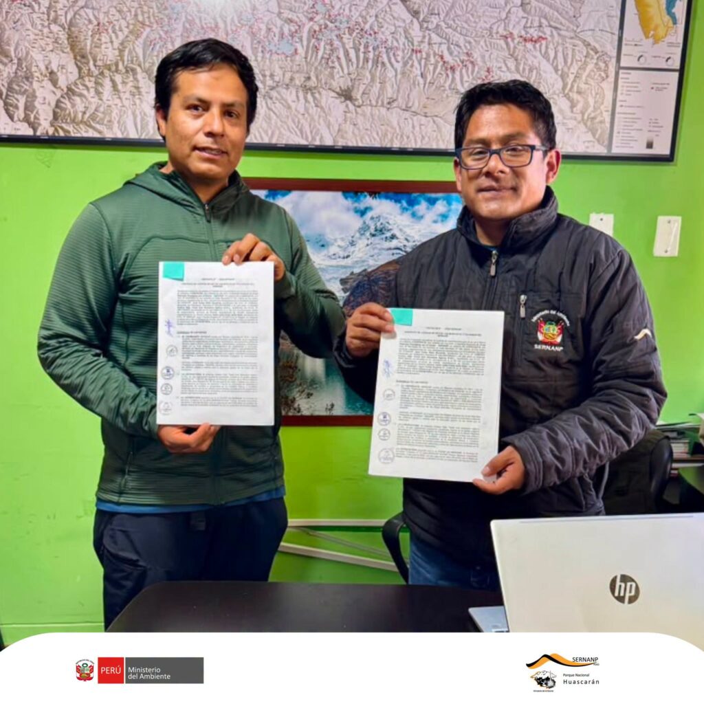 Andean Raju Expeditions and the head of Huascarán National Park holding the signed Aliado por la Conservación agreement at the SERNANP office in Huaraz
