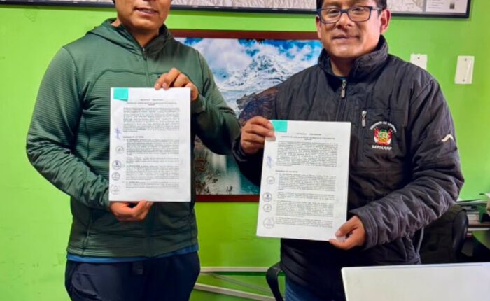 Andean Raju Expeditions and the head of Huascarán National Park holding the signed Aliado por la Conservación agreement at the SERNANP office in Huaraz