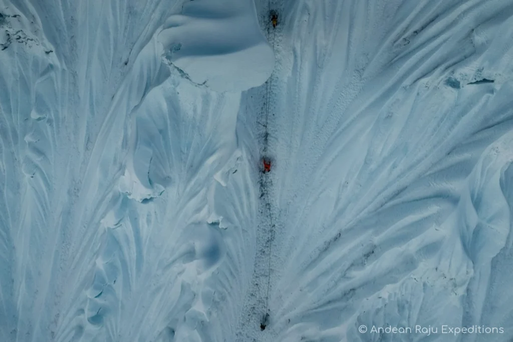 Climber rappelling down Alpamayo’s southwest face on an Abalakov anchor